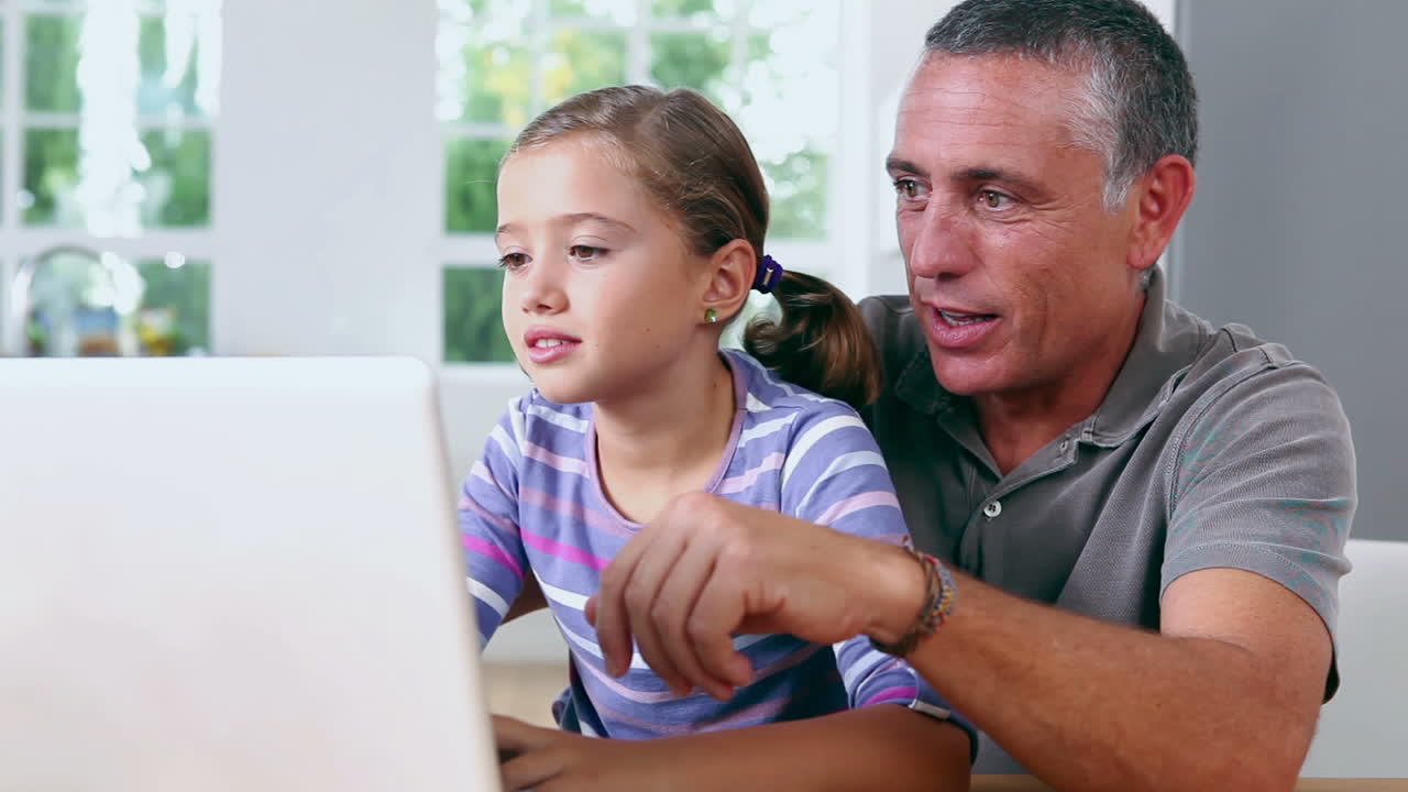 Kakek dan anak perempuan menggunakan laptop