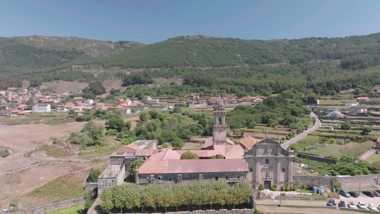 un dron aéreo disparó hacia adelante sobre un monasterio histórico dañado llamado santa maria de oia con un campanario en las estribaciones de una cordillera