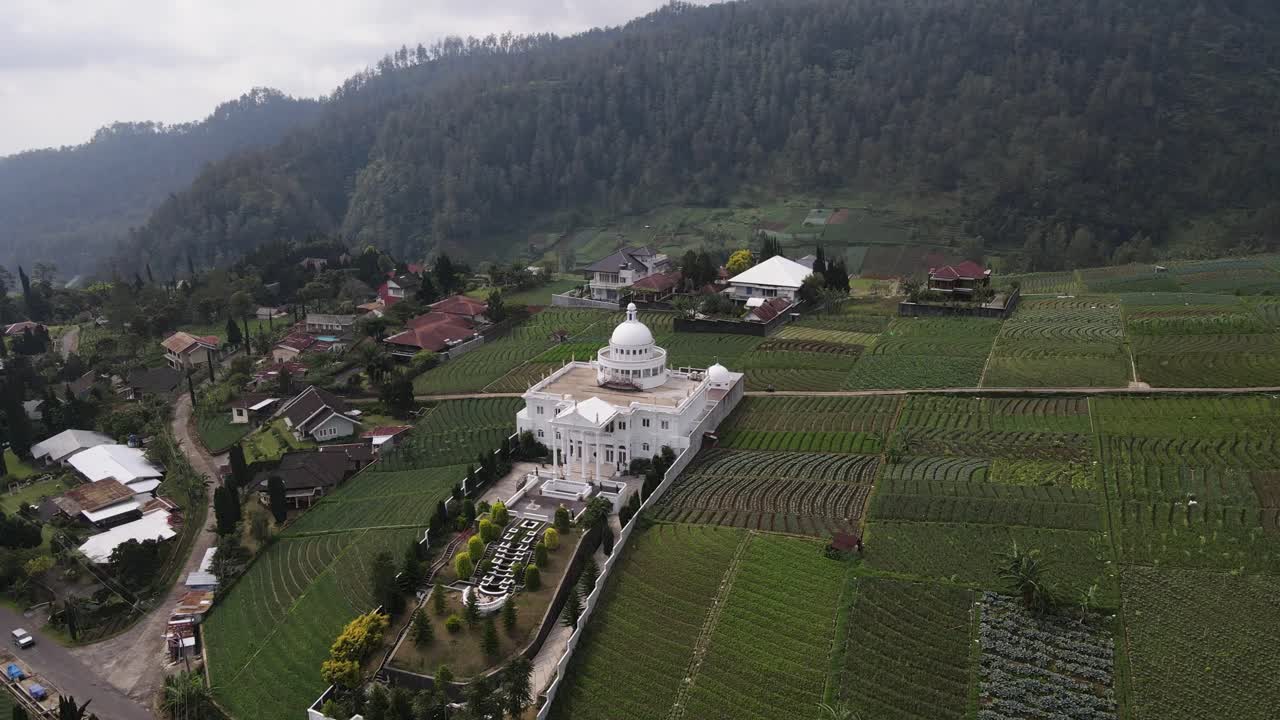 vista aérea, vista de una casa de lujo en las laderas del monte lawu, rodeada de campos de agricultores, un ambiente rural agradable