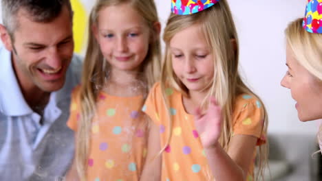 family blowing out candles at a birthday party