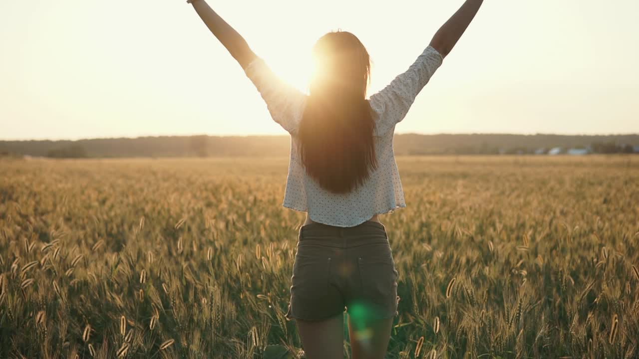 mujer en un campo de trigo al atardecer
