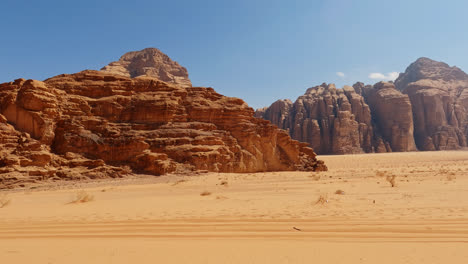 shrubs in foreground reveal desert cliffs and vistas of wadi rum