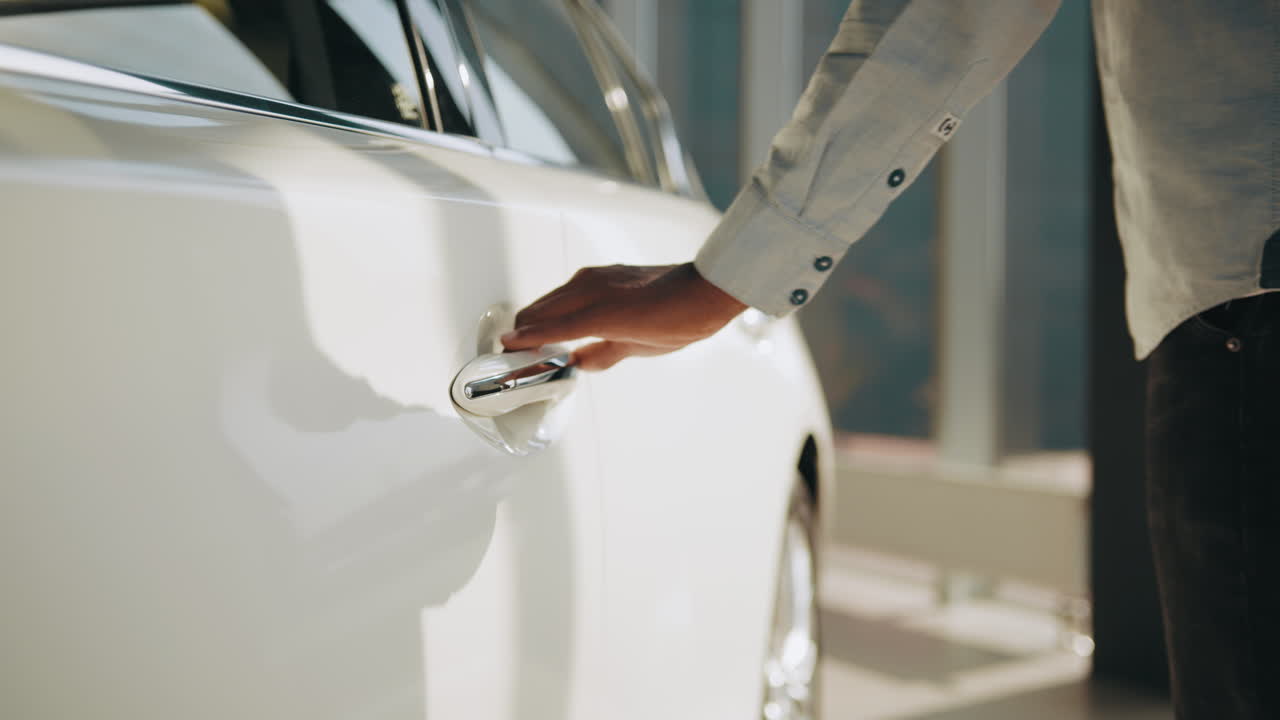 persona abriendo una puerta de coche blanca