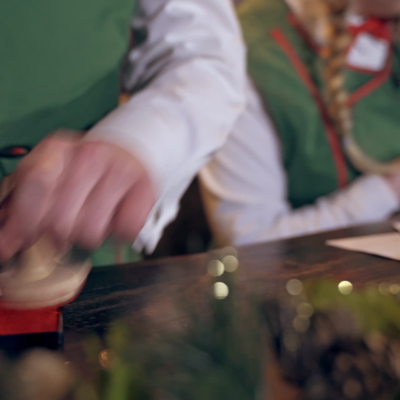 Envelopes on the table for Christmas. Fairy elf puts seal on envelopes. Quick motion. Close-up hands with signet.