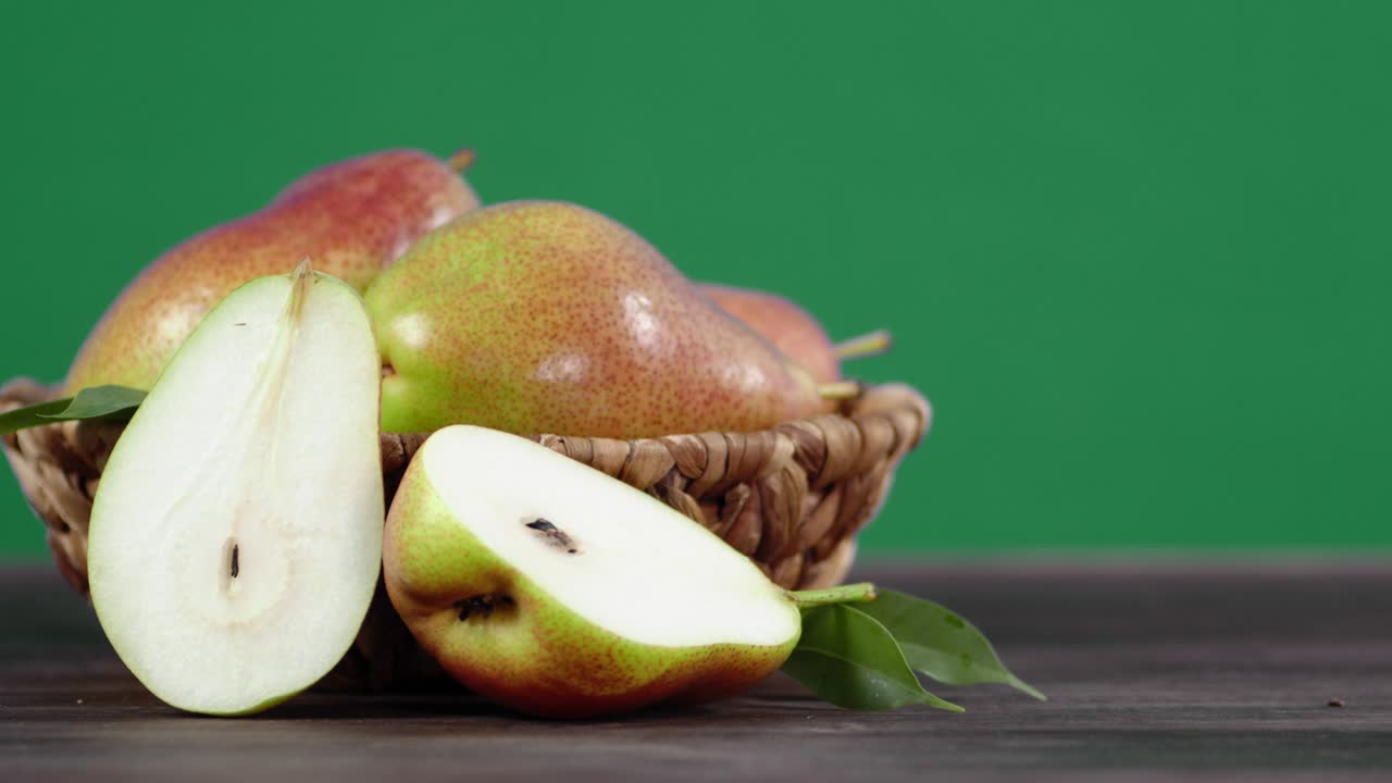 Half and whole pears in the basket rotate slowly.