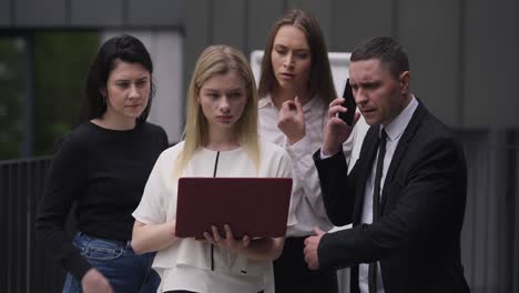 young woman using laptop with colleagues getting bad news about e-business. disappointed stressed caucasian man and women failing startup. business failures concept.