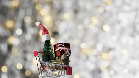 video of shopping trolley with christmas tree and gifts and copy space on fairy lights background