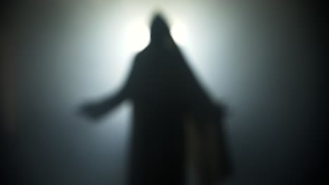 silhouette of resurrection of jesus christ inside the tomb, in bright light, raising his hands in dramatic, cinematic slow motion. perfect for christianity, easter resurrection visual.