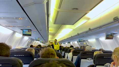 flight attendants demonstrate safety procedures to passengers