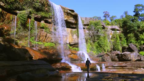 young-man-enjoying-the-pristine-natural-waterfall-falling-from-mountain-top-at-day-from-low-angle-video-taken-at-phe-phe-fall-meghalaya-india