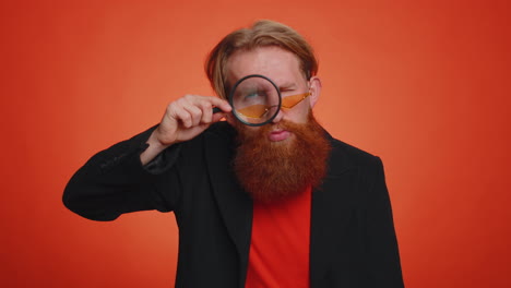 investigator researcher man with magnifying glass near face, looking into camera with big zoom eye