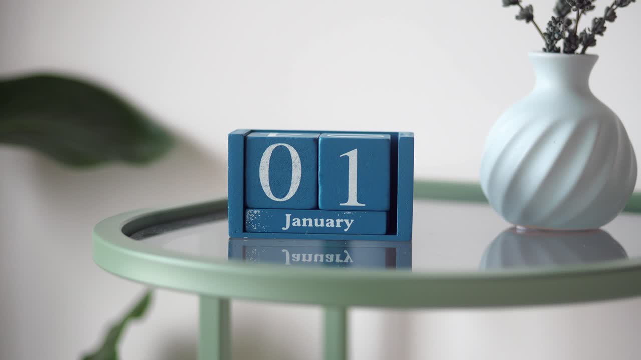 Calendario in legno blu che mostra il 1° gennaio su un tavolo.