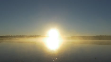 el amanecer sobre un lago de niebla