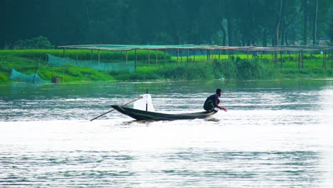 fisherman fishing by hand on clean river in rural bangladesh during the day