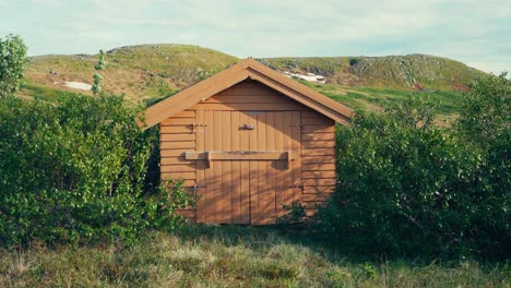 Small-Wooden-Shed-With-Mountain-Range-Background