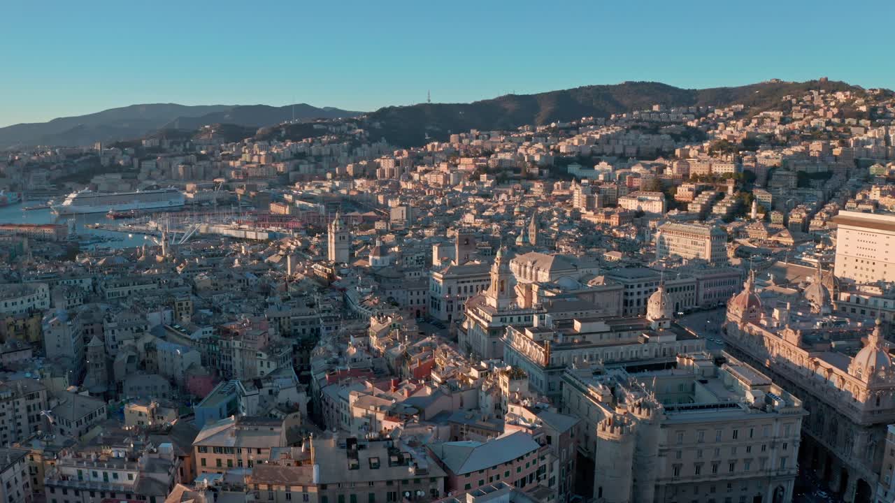 Veduta aerea in ascesa al tramonto sopra gli edifici storici della città portuale di Genova, Liguria.