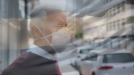 animation of flag of argentina waving over man wearing face mask during covid 19 pandemic