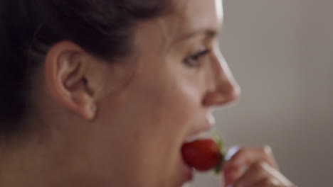 happy woman eating strawberry, close up, shot on r3d