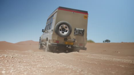 Low-Angle-Aufnahme-Eines-Geländewagens,-Der-Im-Sommer-Durch-Die-Wüste-Fährt