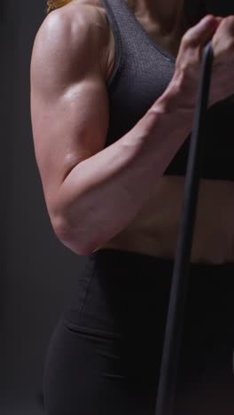 Vertical-Video-Close-Up-Shot-Of-Mature-Woman-Wearing-Gym-Fitness-Clothing-Exercising-With-Resistance-Band-2