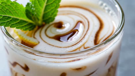 close-up of iced latte with chocolate swirl and mint lemon garnish
