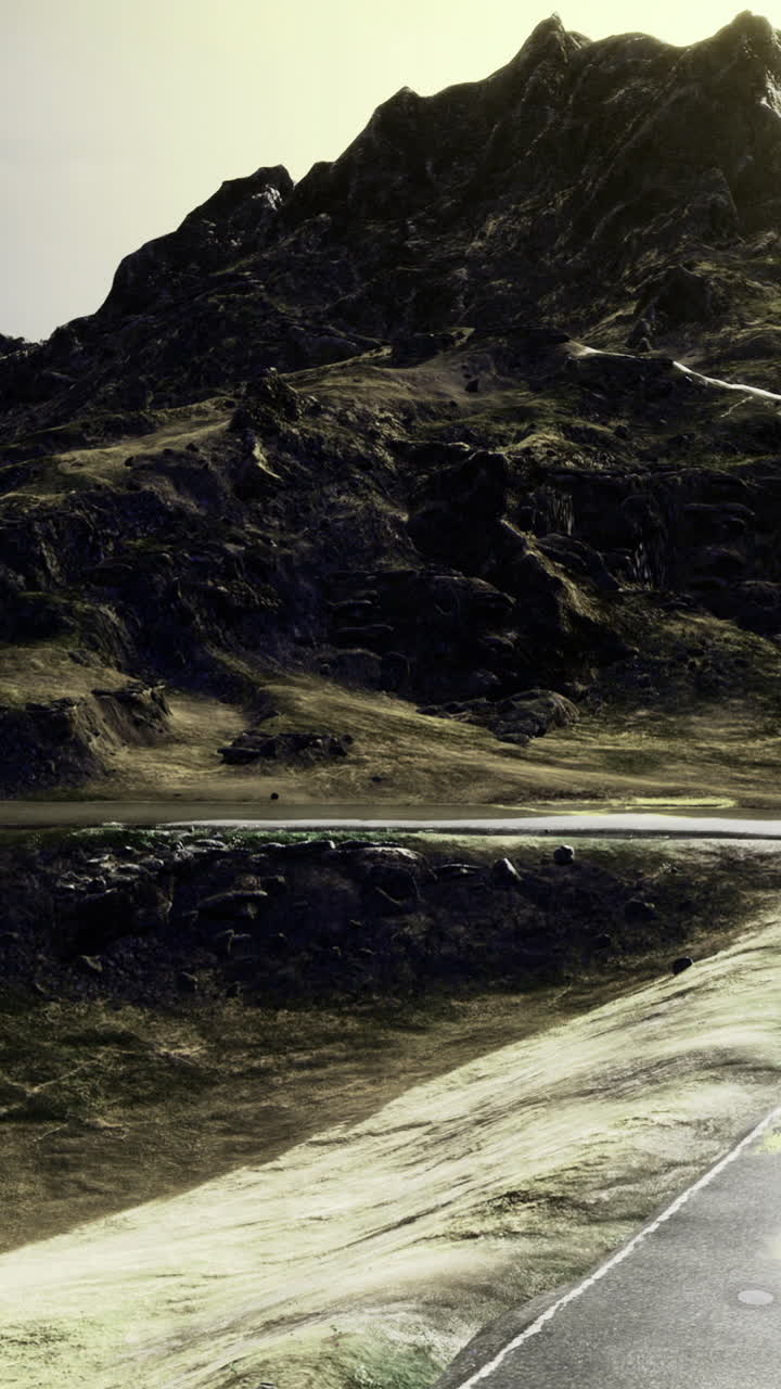 Winding road through a dramatic mountain landscape during golden hour