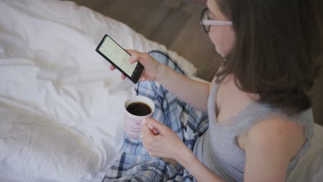 Mujer-Joven-Tomando-Café-Y-Usando-El-Teléfono-Inteligente