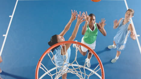 playing basketball, women reaching for ball near hoop on court