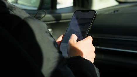 person using a smartphone inside a car