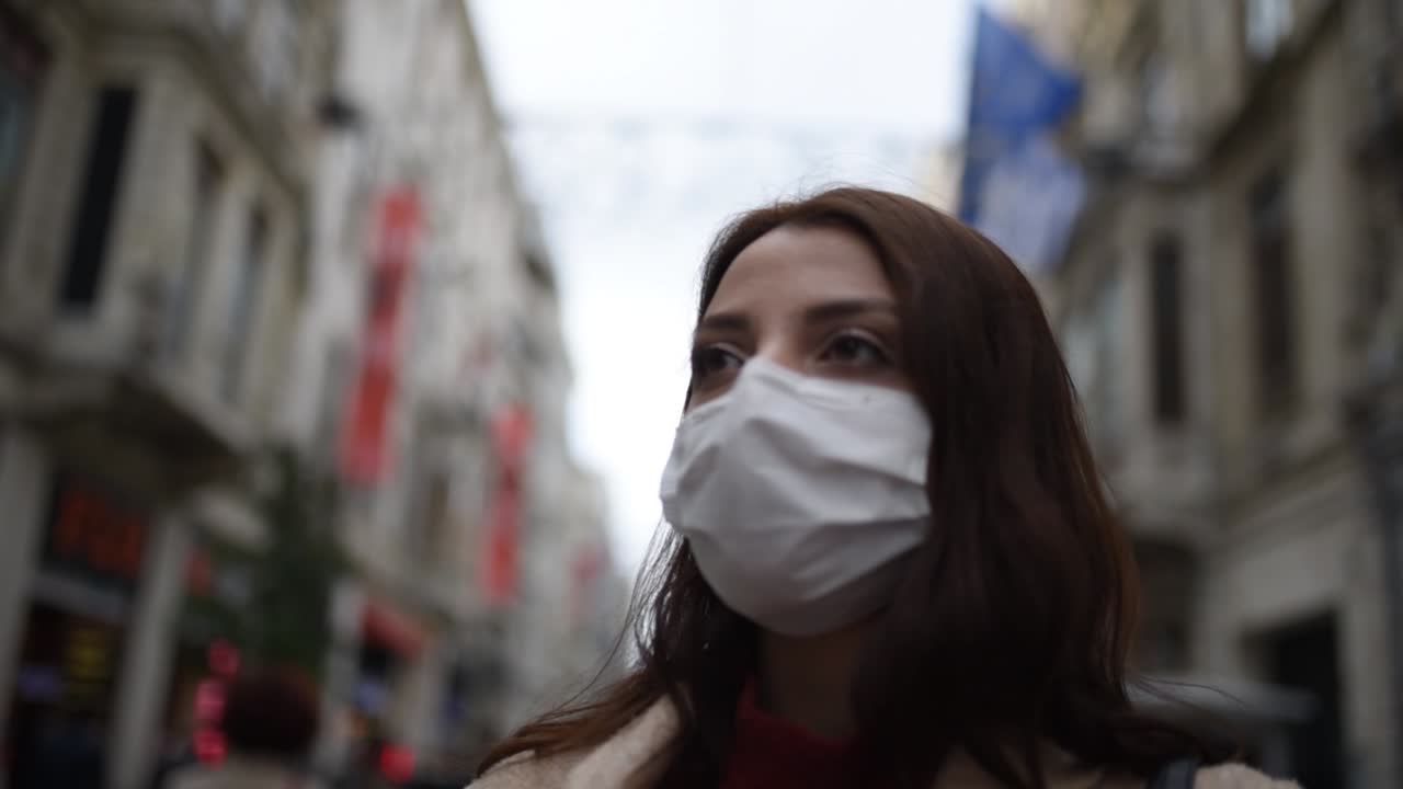 hermosa chica con máscara médica protectora y ropa de moda se encuentra en la calle