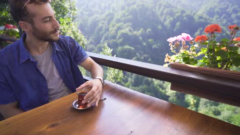 Young-man-drinking-beverage-in-nature.