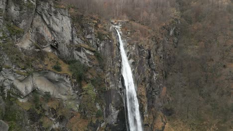 Nieve-Cayendo-Frente-A-Una-Cascada-Cascata-Di-Foroglio,-Ubicada-En-El-Pueblo-De-Cavergno-En-El-Distrito-De-Vallemaggia-En-El-Cantón-De-Ticino,-En-Suiza