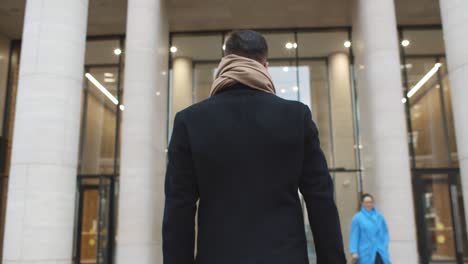 back view of successful businessman entering business center