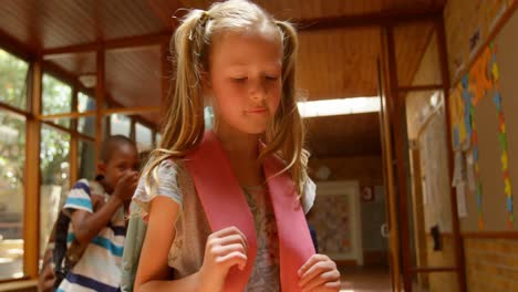 niños de la escuela intimidando a una niña triste en el corredor de la escuela primaria 4k
