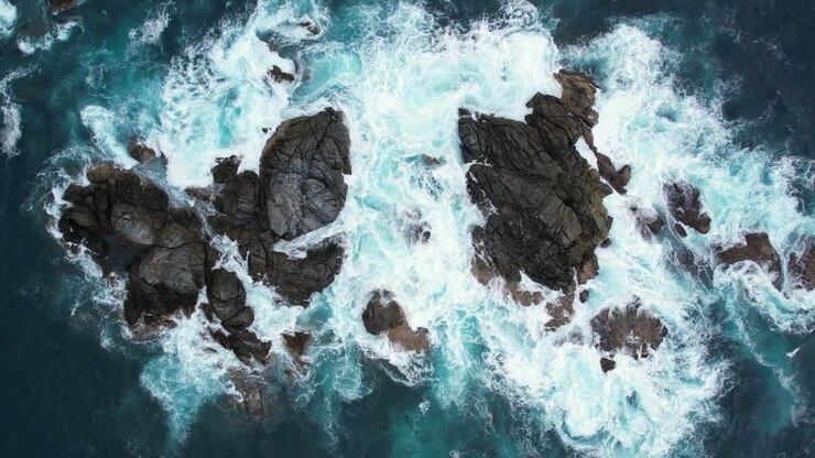 Riprese aeree delle onde dell'oceano che colpiscono un gruppo di rocce vicino a Playa del Muerto a Mazunte, Oaxaca, al rallentatore.