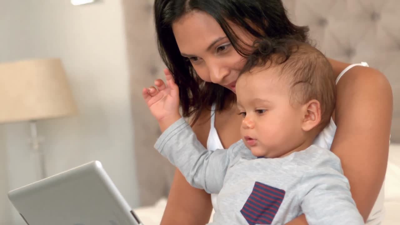 madre con su bebé lindo usando una tableta digital