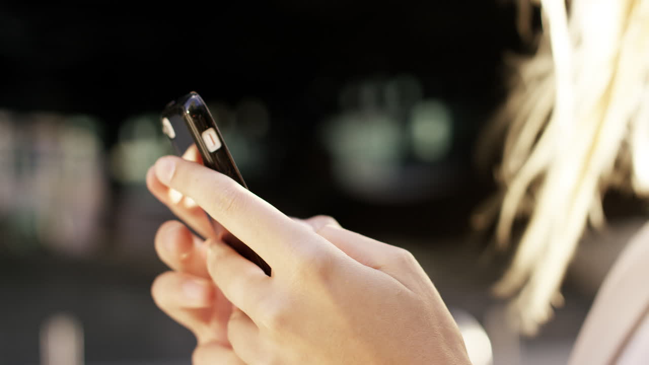 스마트 폰을 사용하는 아름다운 금발 여성 태양 플레어 태양광 에너지 개념