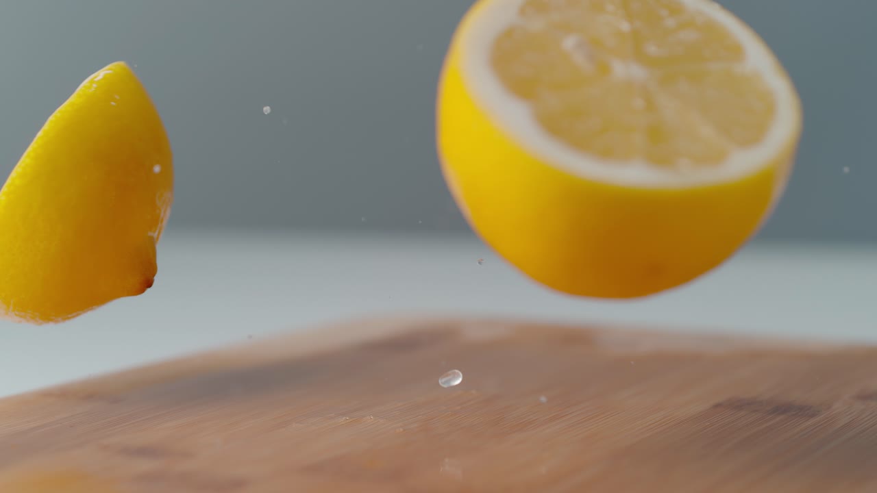 Lemon Halves Bouncing on Wooden Cutting Board
