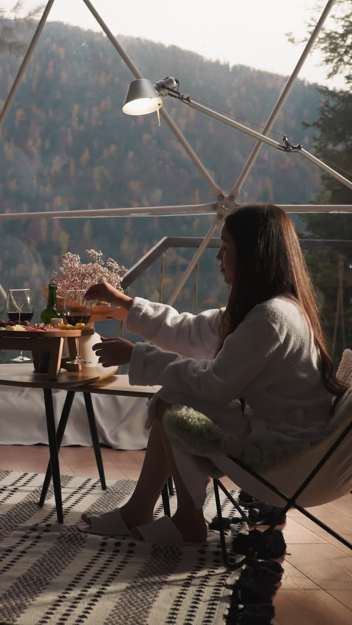 Man and woman eat cheese snack in glamping round house. Happy couple spends romantic date with delicacies at eco resort. Comfort in wilderness