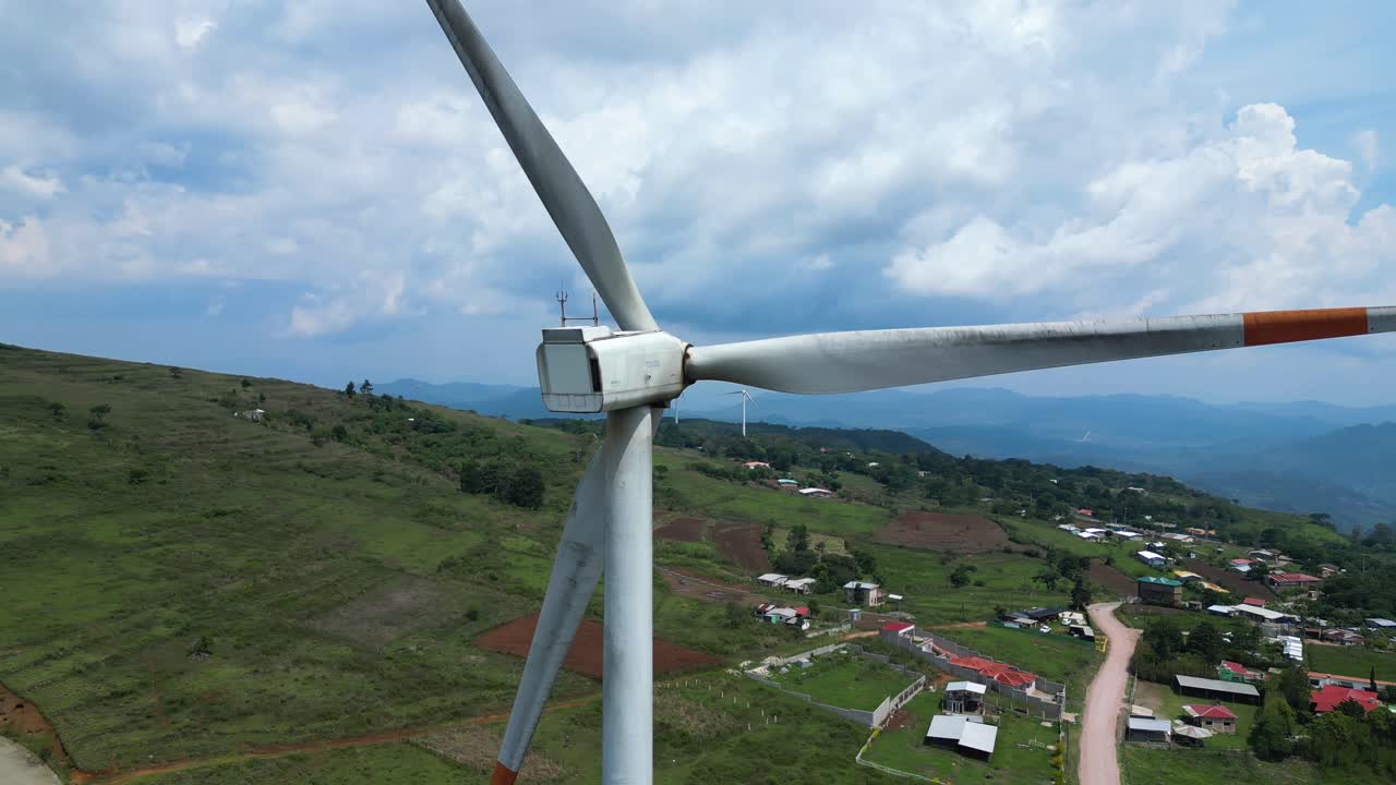 Drone view of modern windmill over rural terrain, sustainable power and eco transition theme