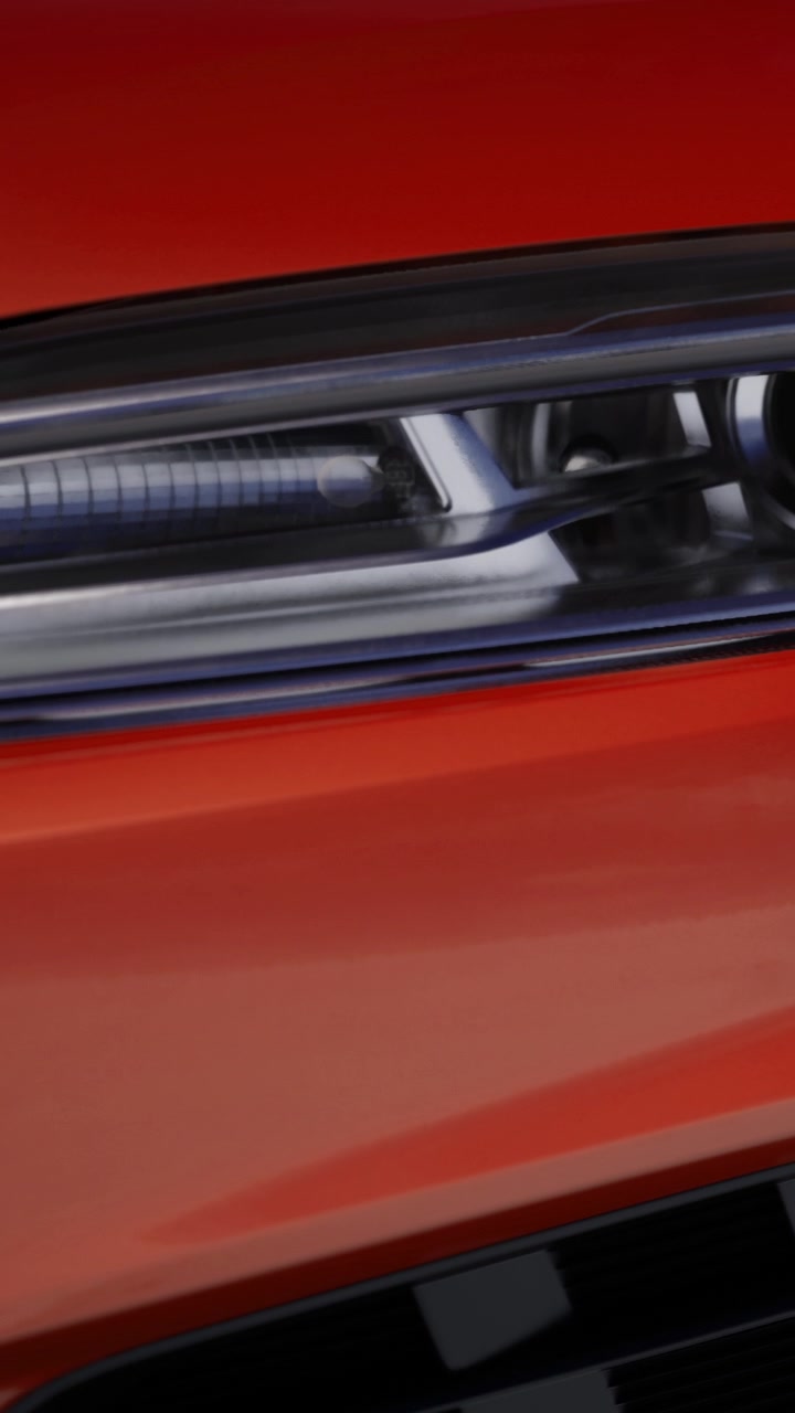 Close up view of a modern car headlight in bright orange color