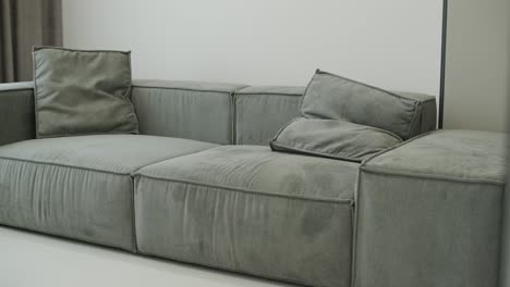 modern gray sofa with soft cushions in minimalist living room