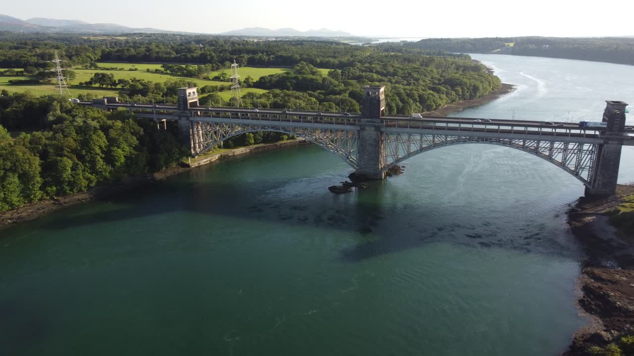 일몰 슬로우 푸시 인에서 반짝이는 웨일스 메나이 해협 위의 조감도 퐁 브리타니아 다리