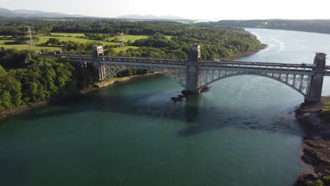 Vista-Aérea-Del-Puente-Pont-Britannia-Sobre-El-Brillante-Estrecho-De-Welsh-Menai-Al-Atardecer-Empuje-Lento-Hacia-Adentro