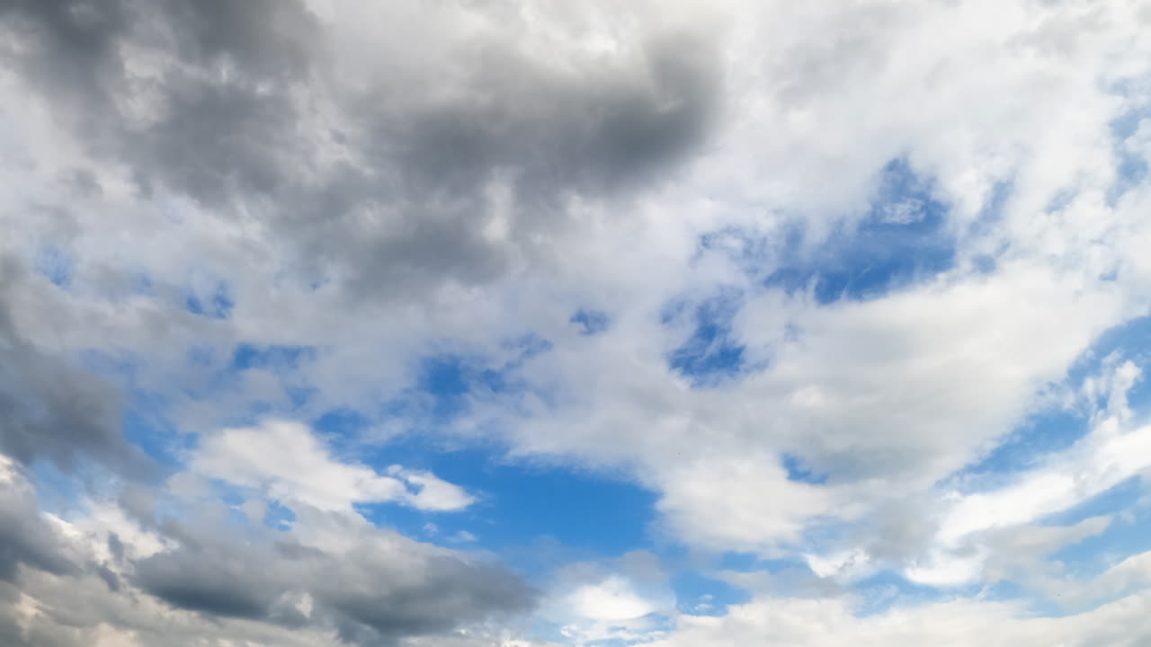 Dramatic grey cloudscape spreading by the atmosphere. Rain formation in the sky. Low angle view. Timelapse.