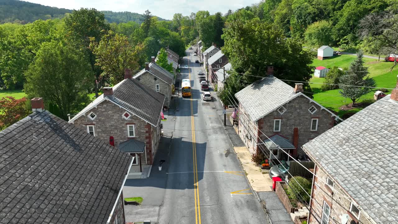 Scuolabus giallo che attraversa una strada storica in una città mineraria nell'America rurale