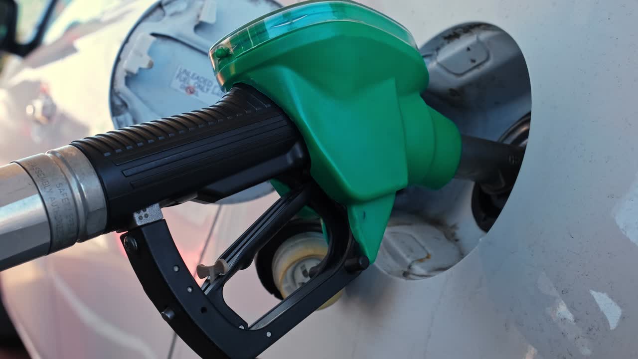 주유소 가솔린 프 노즐 권총이 자동차 크 채우기 크에 입되어 있습니다.