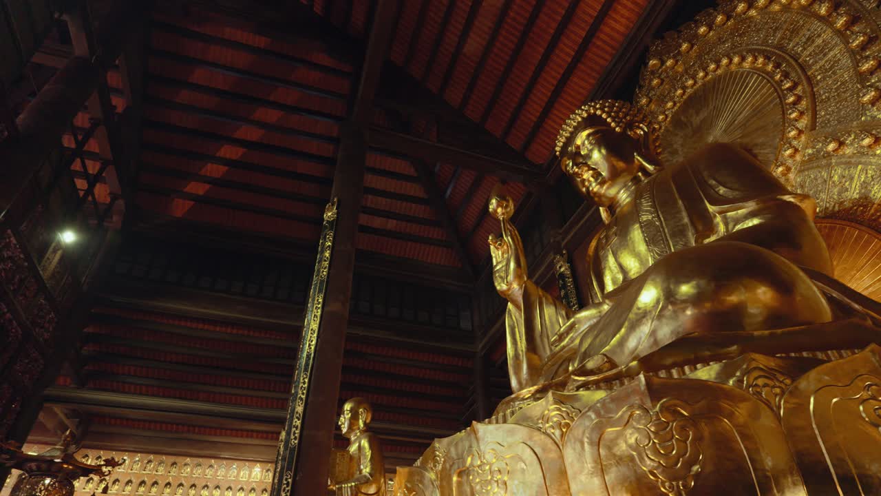 装飾 された 寺院 の 内装 に 置か れ た 金 の 仏像