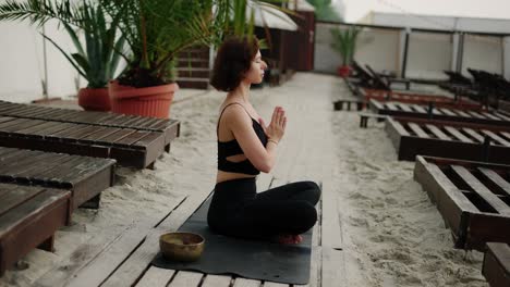 La-Mujer-Se-Sienta-En-Meditación-En-La-Playa.