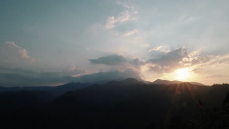 el sol brillando detrás de las montañas